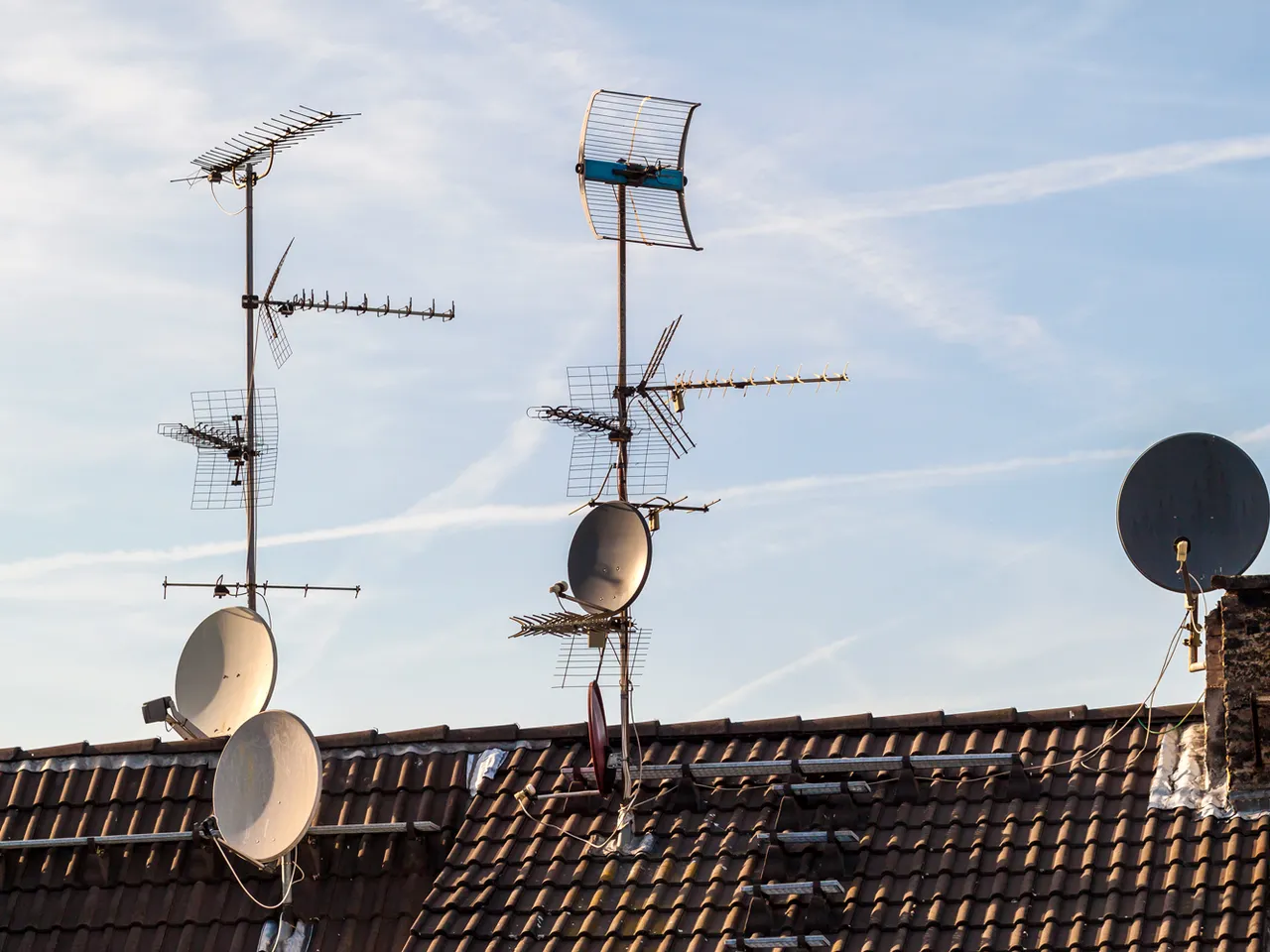 Antennes rateaux et paraboles installees sur une toiture en tuiles